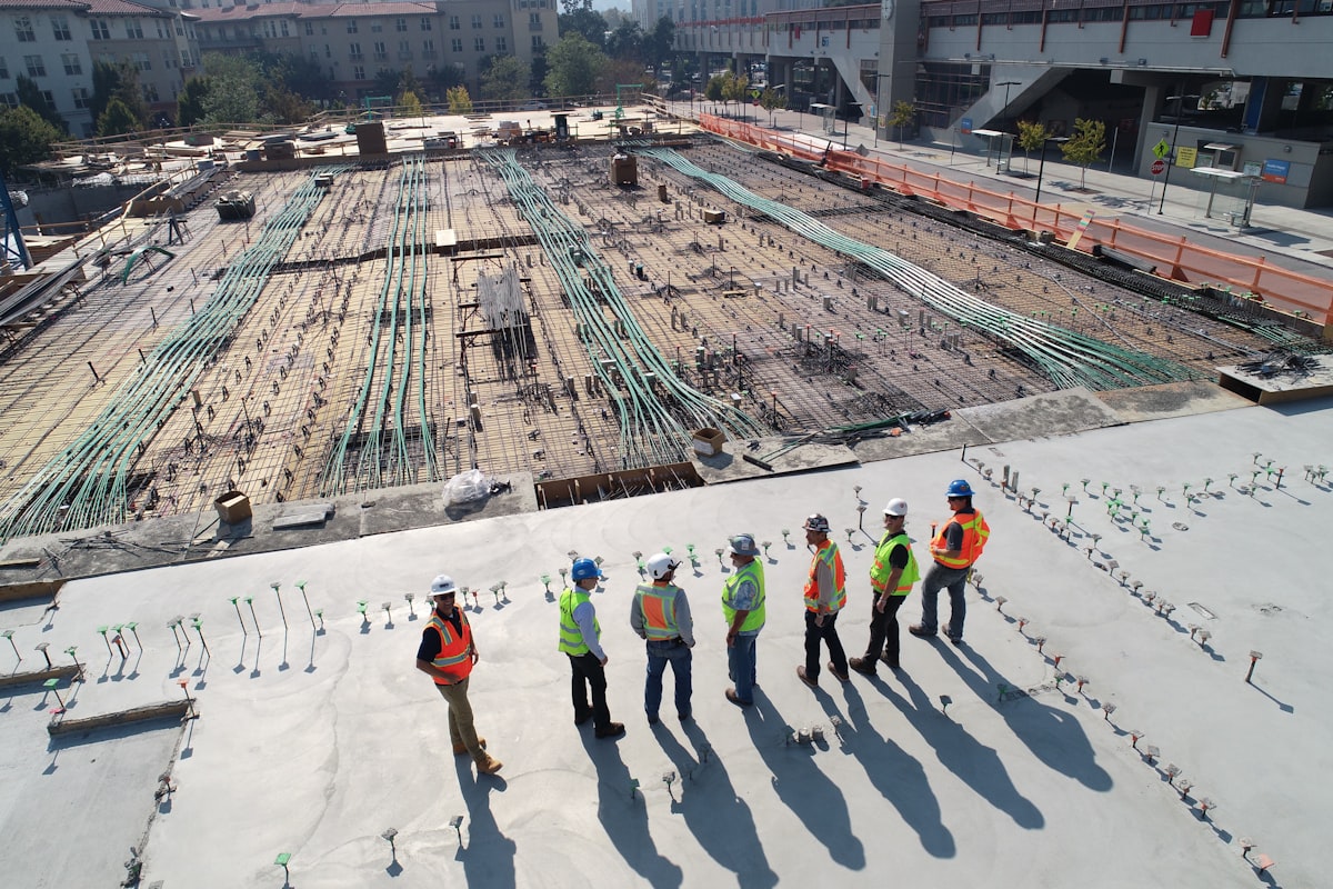 Profesionales de la construcción con equipo de seguridad revisando una obra